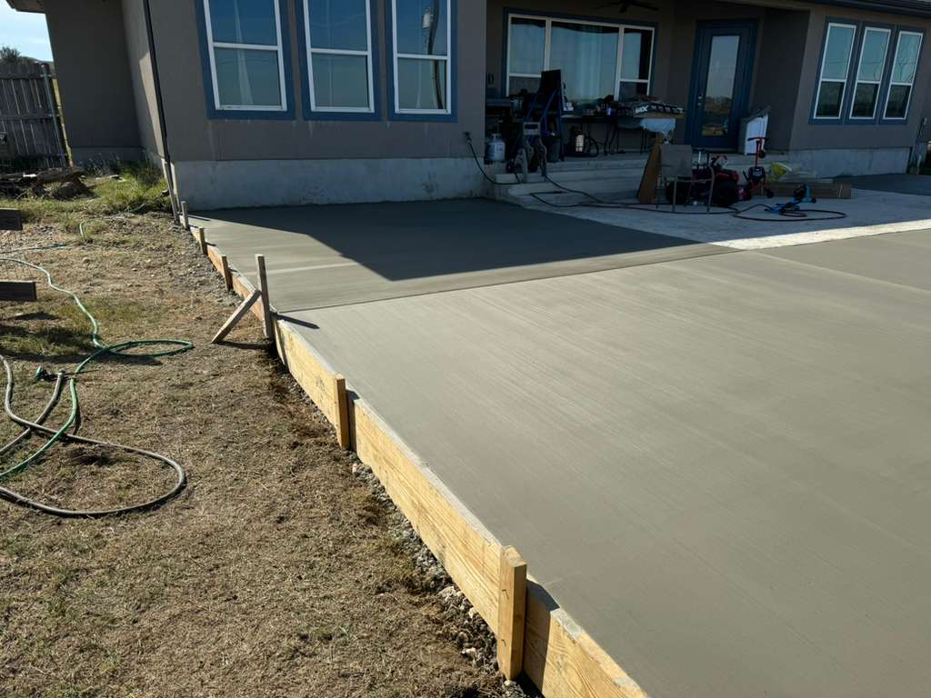 Crew power-troweling a fresh concrete pour in Alamo Ranch San Antonio TX