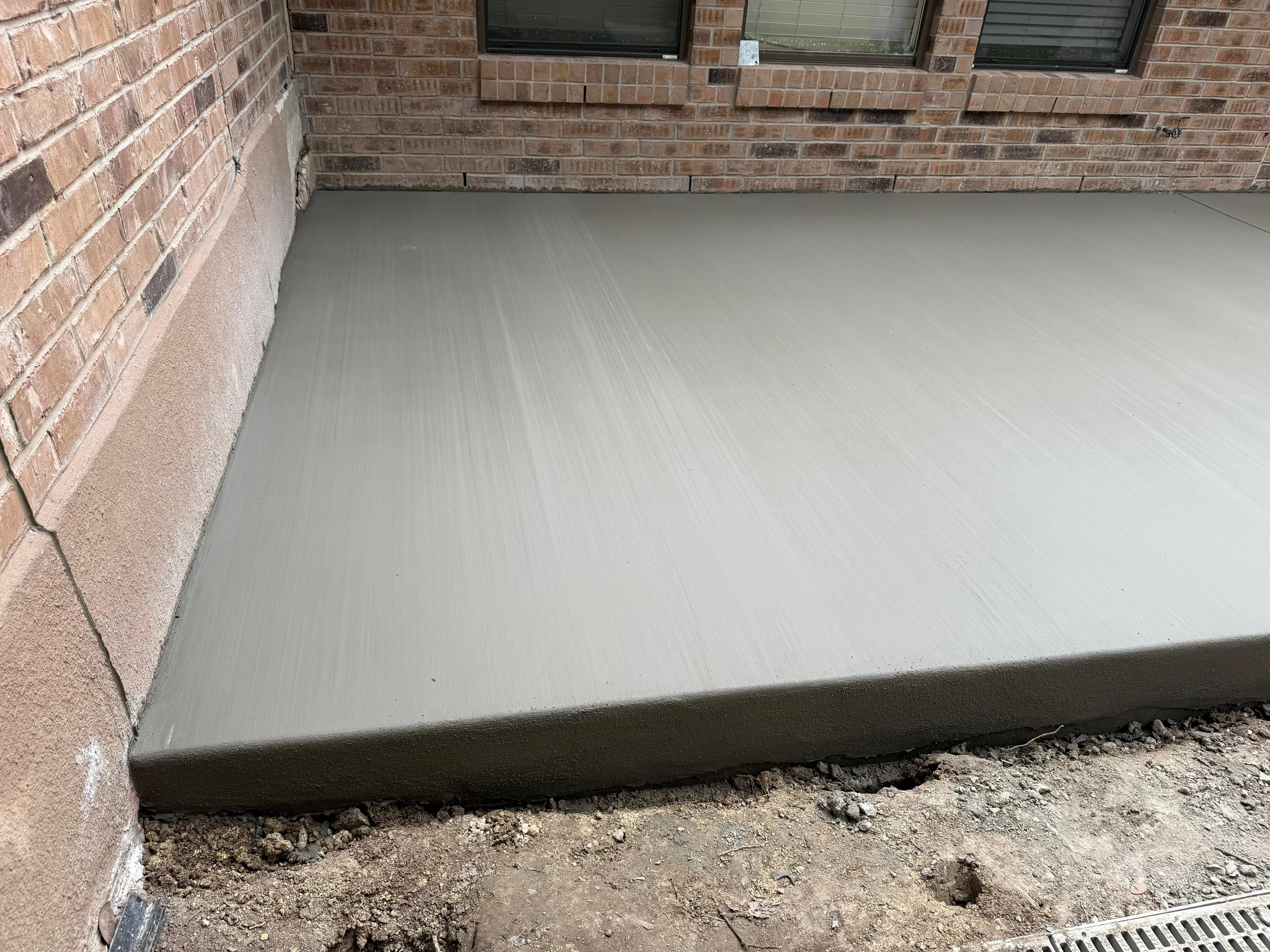Smooth-finish concrete patio against brick home, San Antonio TX