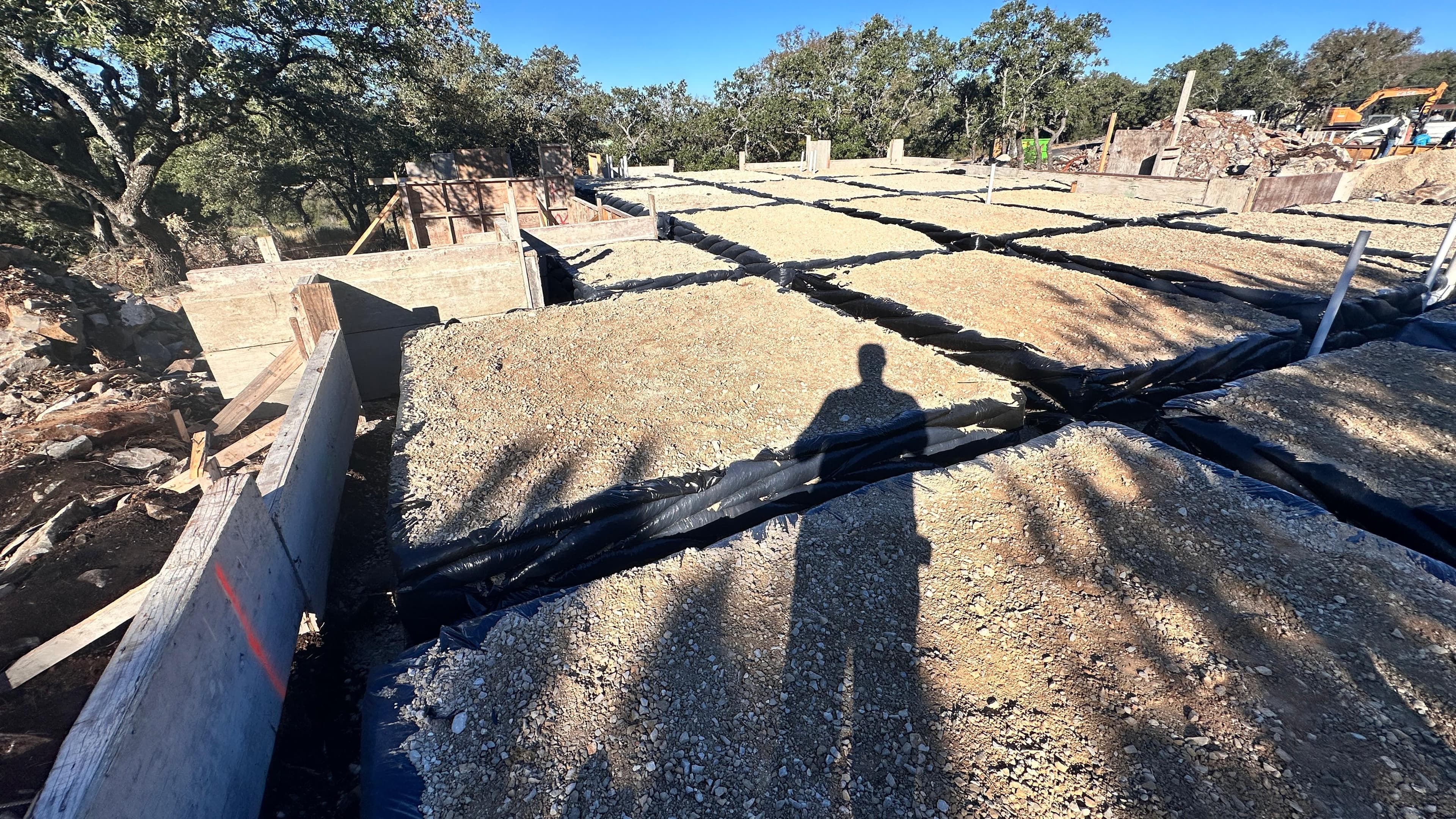New home foundation prep at The Dominion San Antonio TX — gravel pad and vapor barrier ready for pour