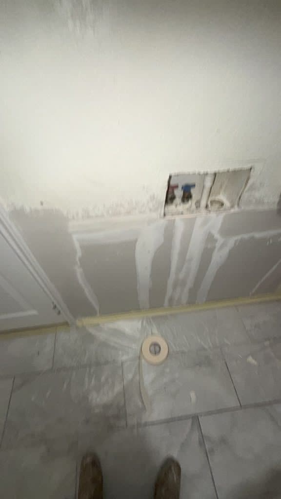 New drywall installed and mudded in the Cibolo laundry room, washer box opening left cut for the valves