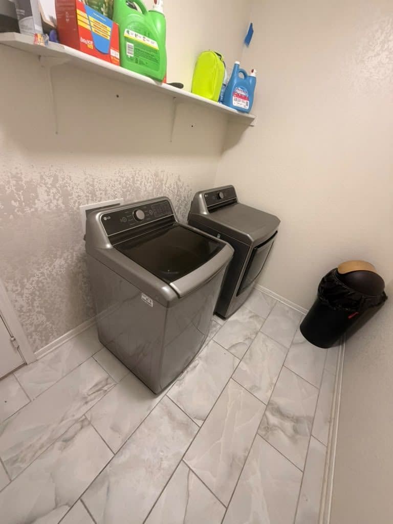 Cibolo laundry room put back together — new drywall hand-textured to match, baseboard reinstalled, washer and dryer back in place